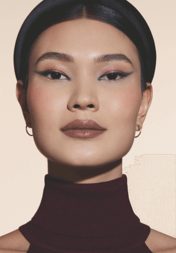 Mulher com cabelo escuro e tiara na cabeça com sombra nos olhos e blush nas bochechas