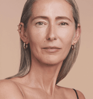 Mulher branca, olhos verdes de meia idade e sem maquiagem